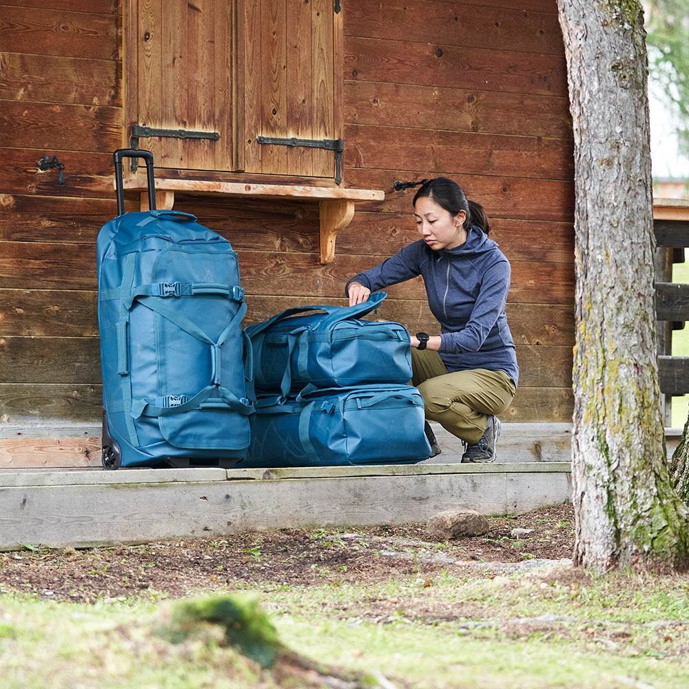 Fjern - Orädda 105L Wheeled Bag (Petrol) | The Orädda 105L Roller Duffle Bag is a rugged travel companion designed for durability