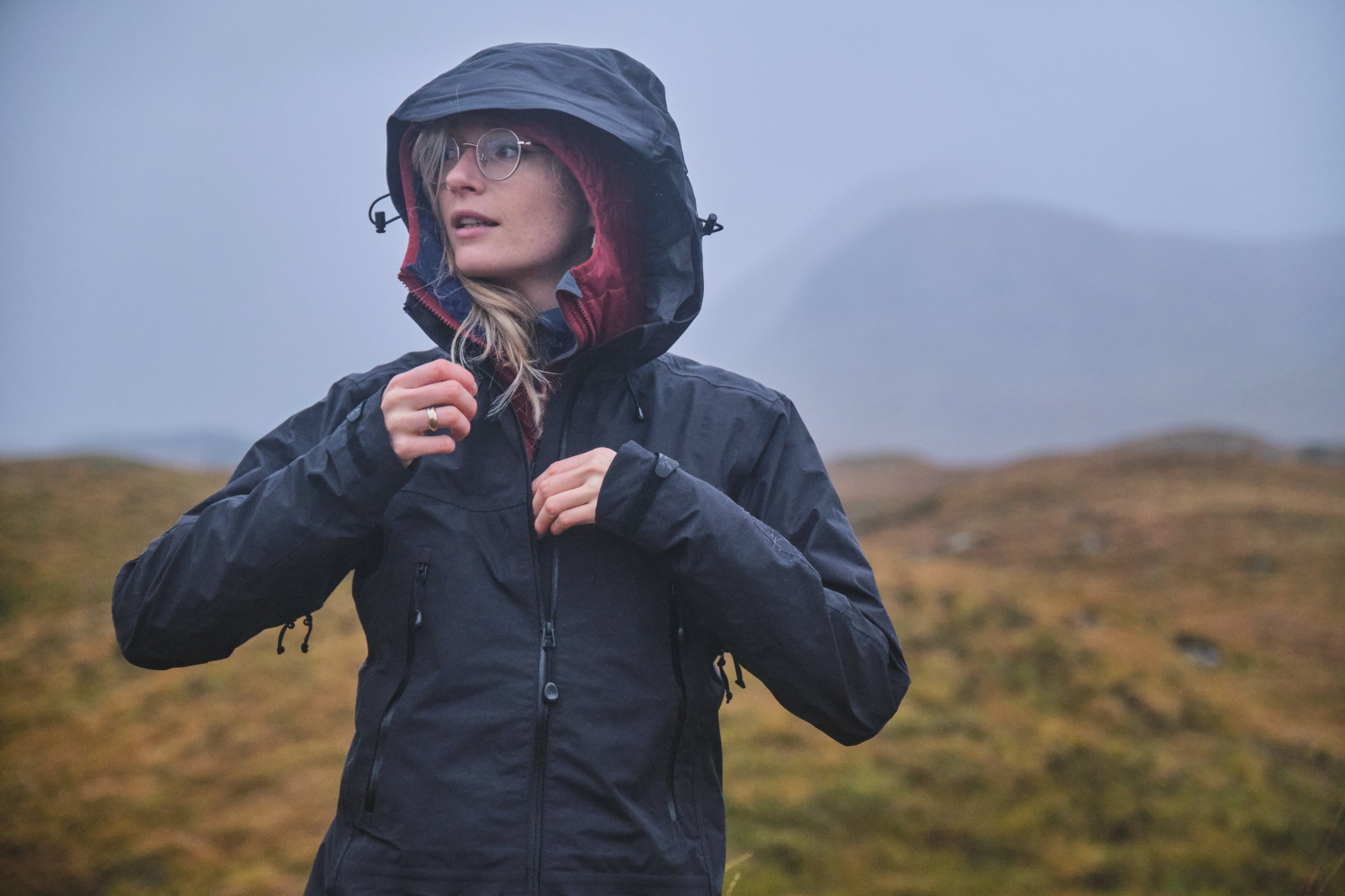 A woman wearing a black hooded rain jacket