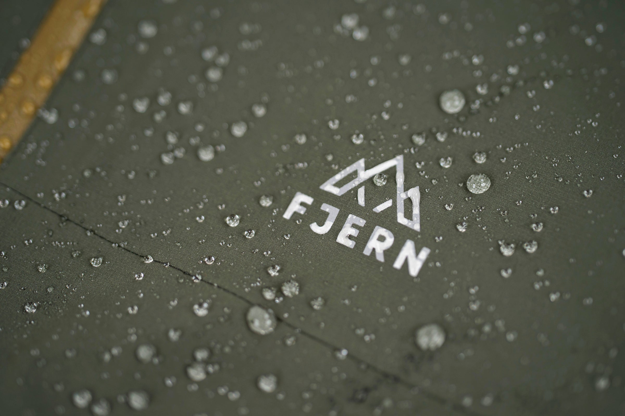 Water droplets beading on green Fjern waterproof jacket