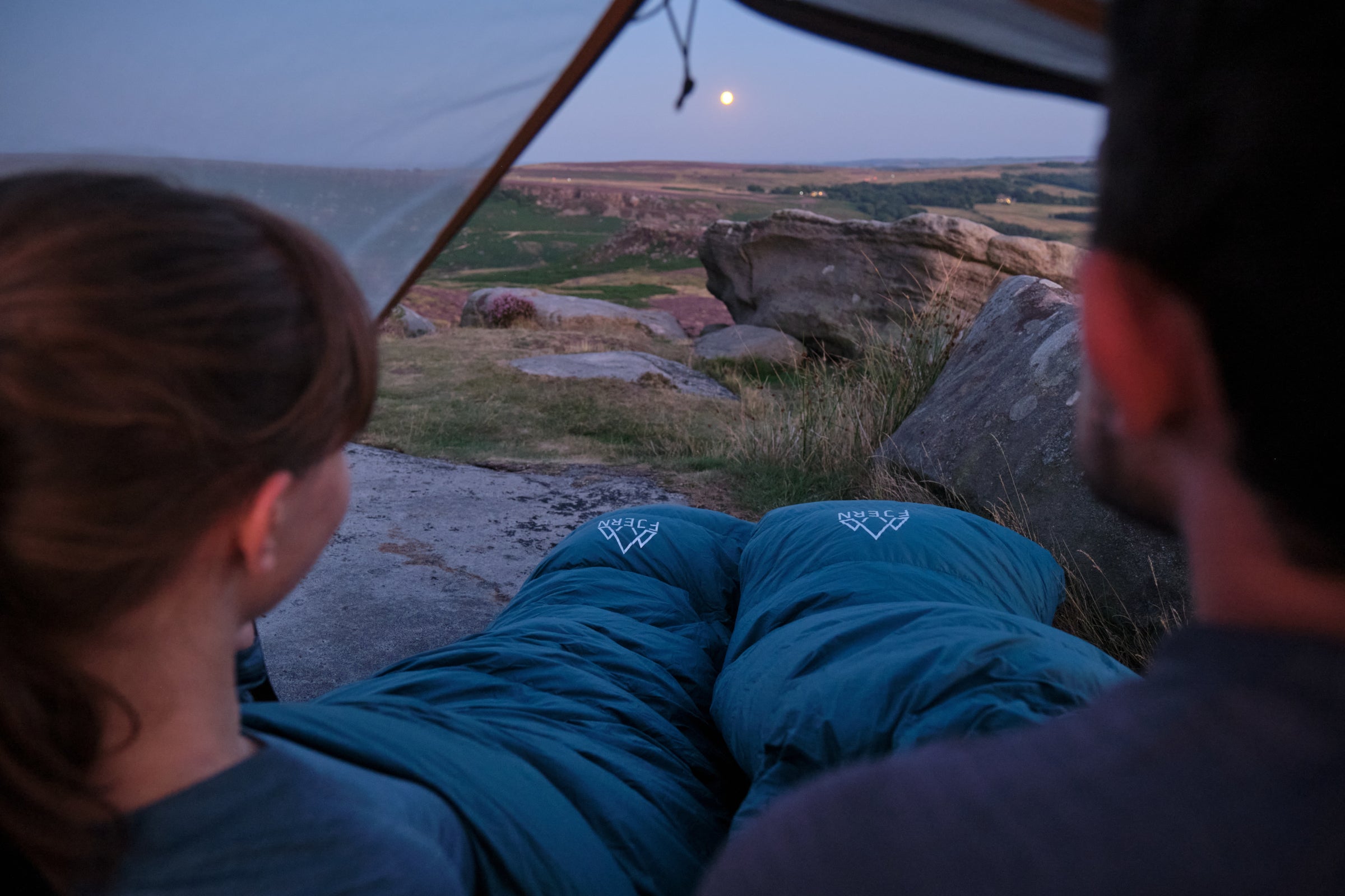 Two people in sleeping bags inside a tent