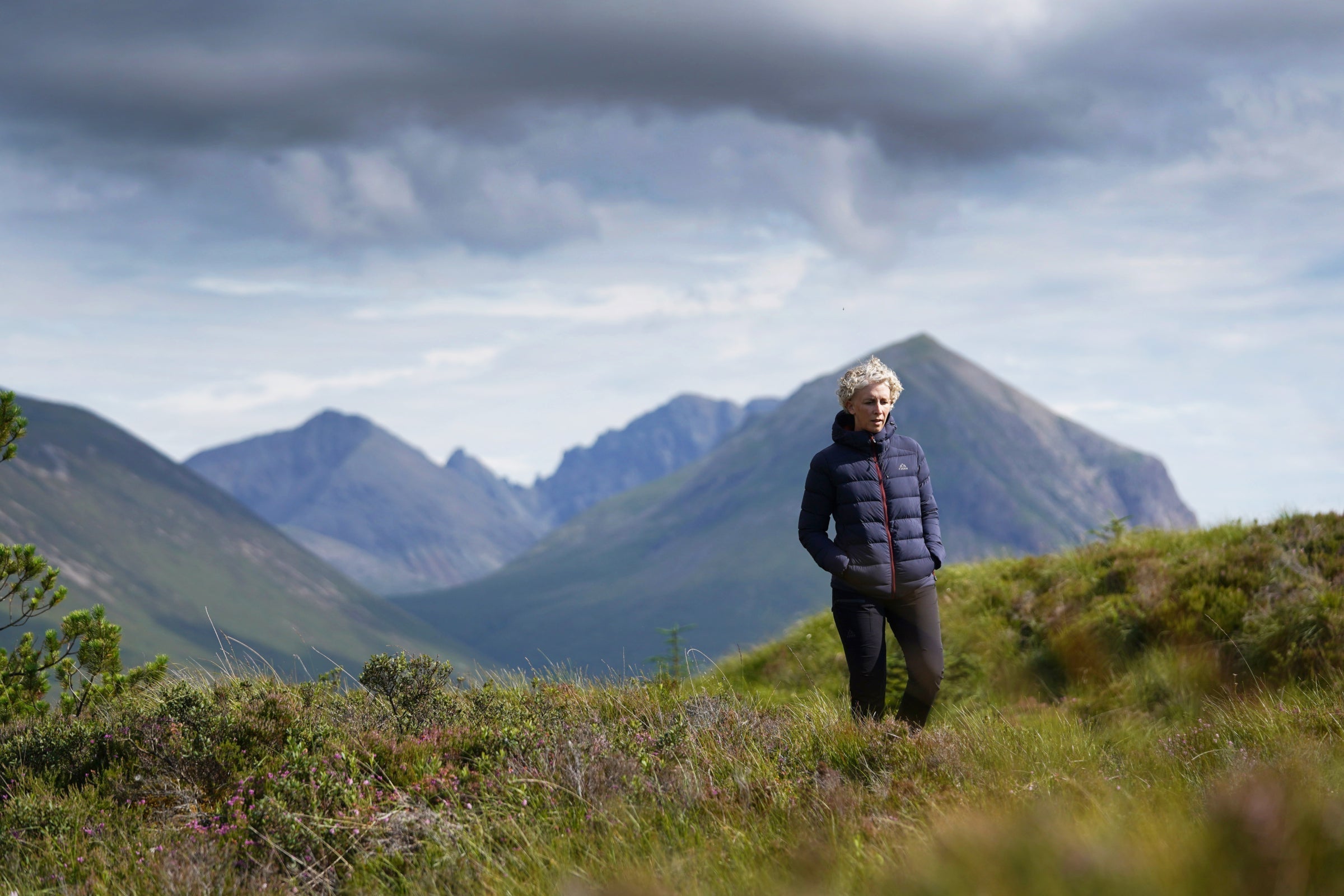 Person wearing a Fjern down jacket hiking in the mountains