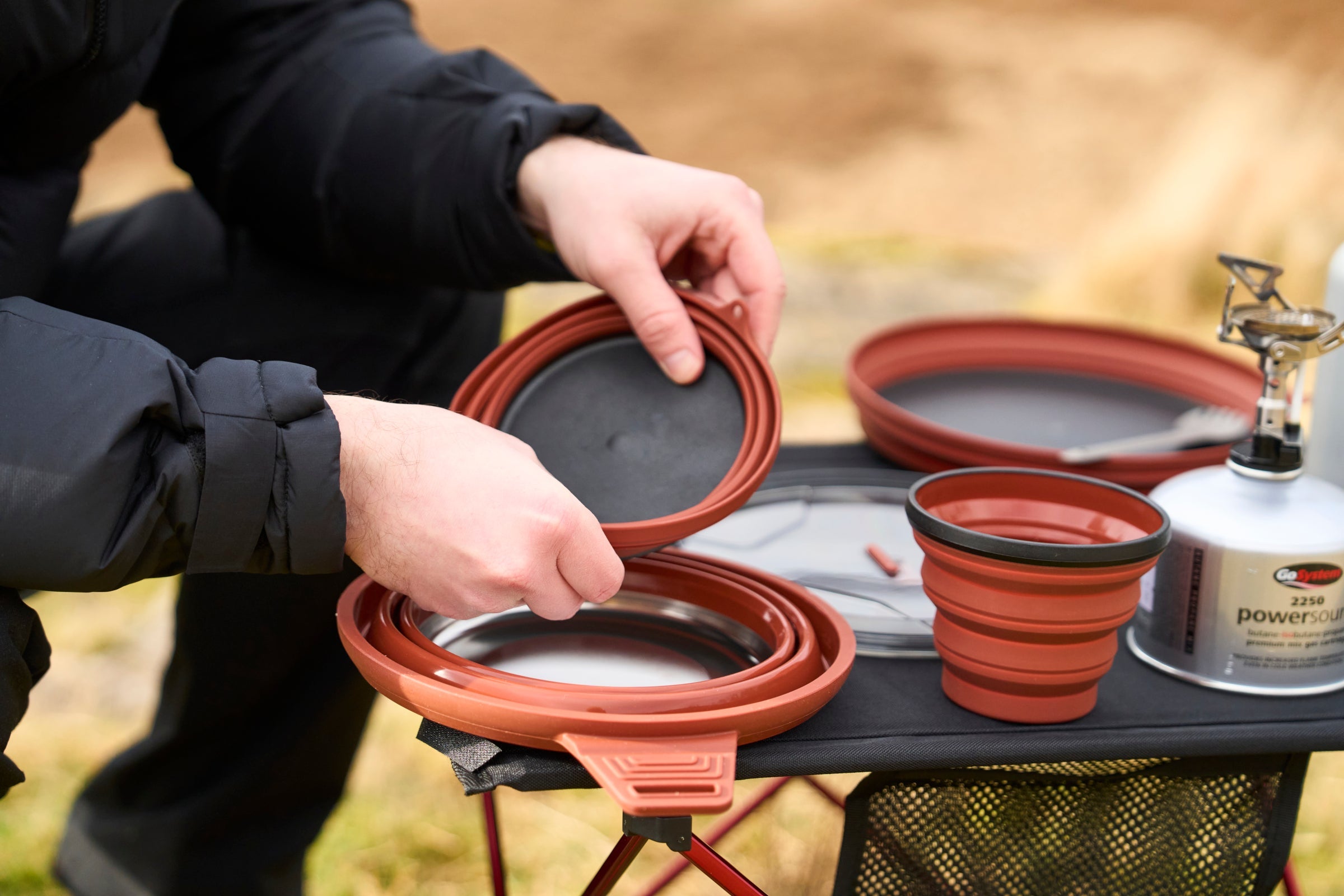 Fjern collapsible cookware set in use outdoors, featuring a compact pan, bowl, and cup on a camping table with a portable stove