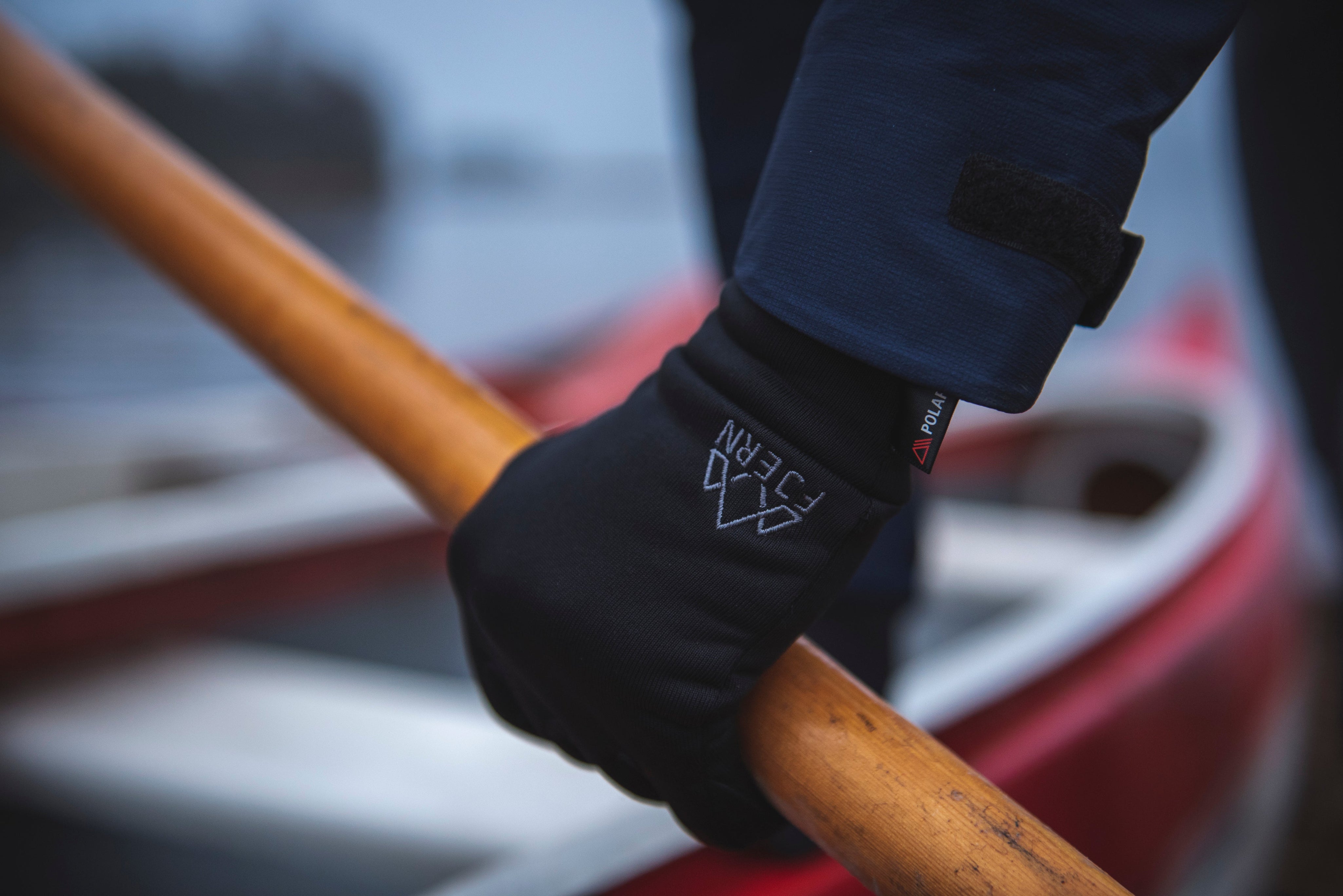Fjern Polartec Gloves gripping an oar in preparation for a lake canoe expedition