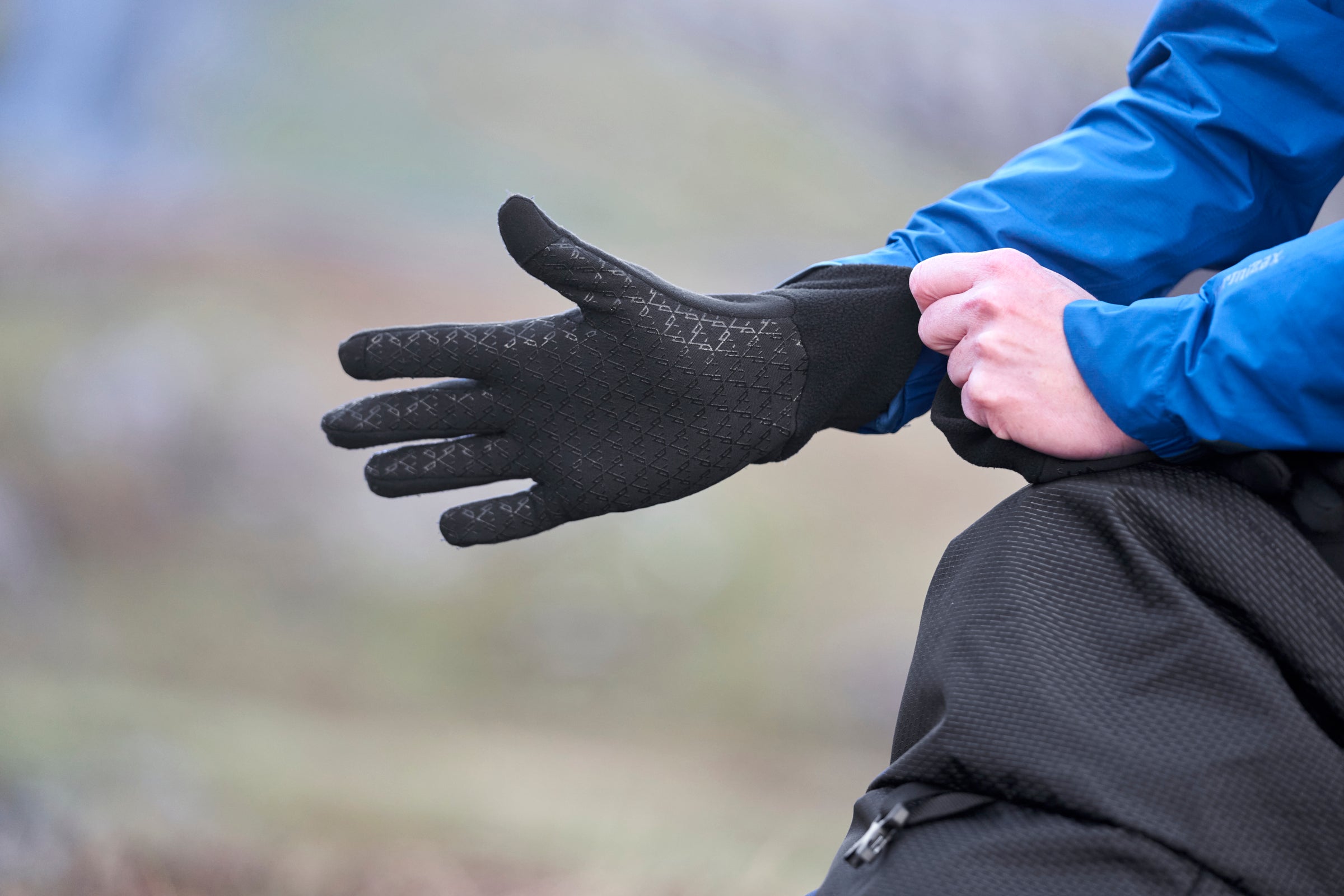 Person putting on black gloves
