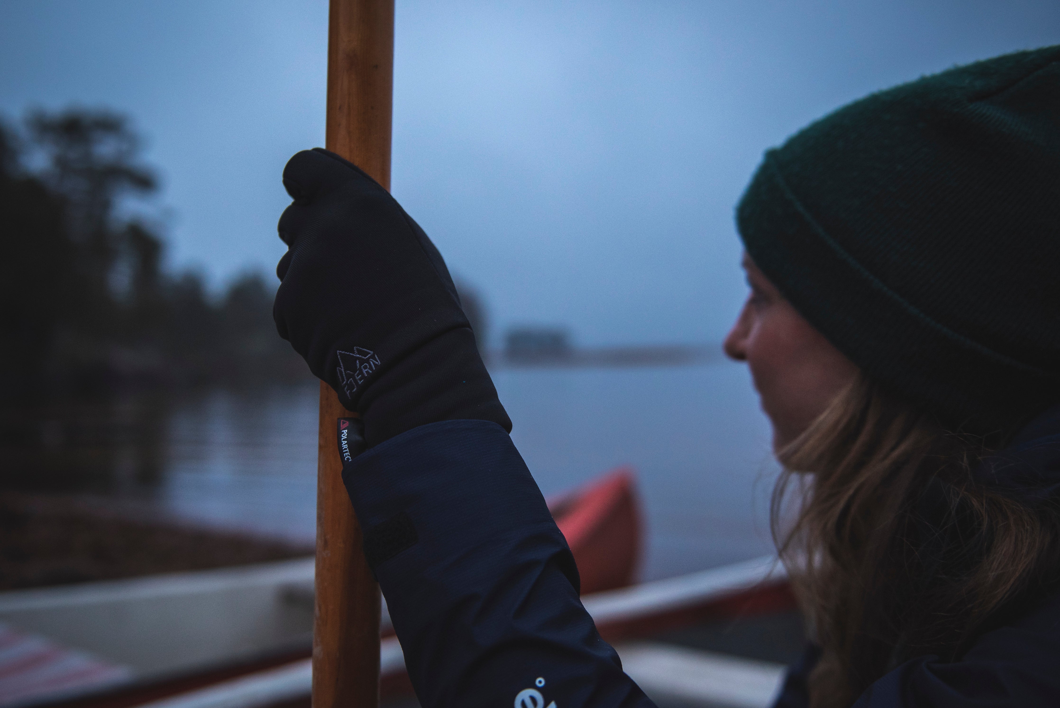 Fjern Polartec Gloves holding a boat mast on a foggy lake