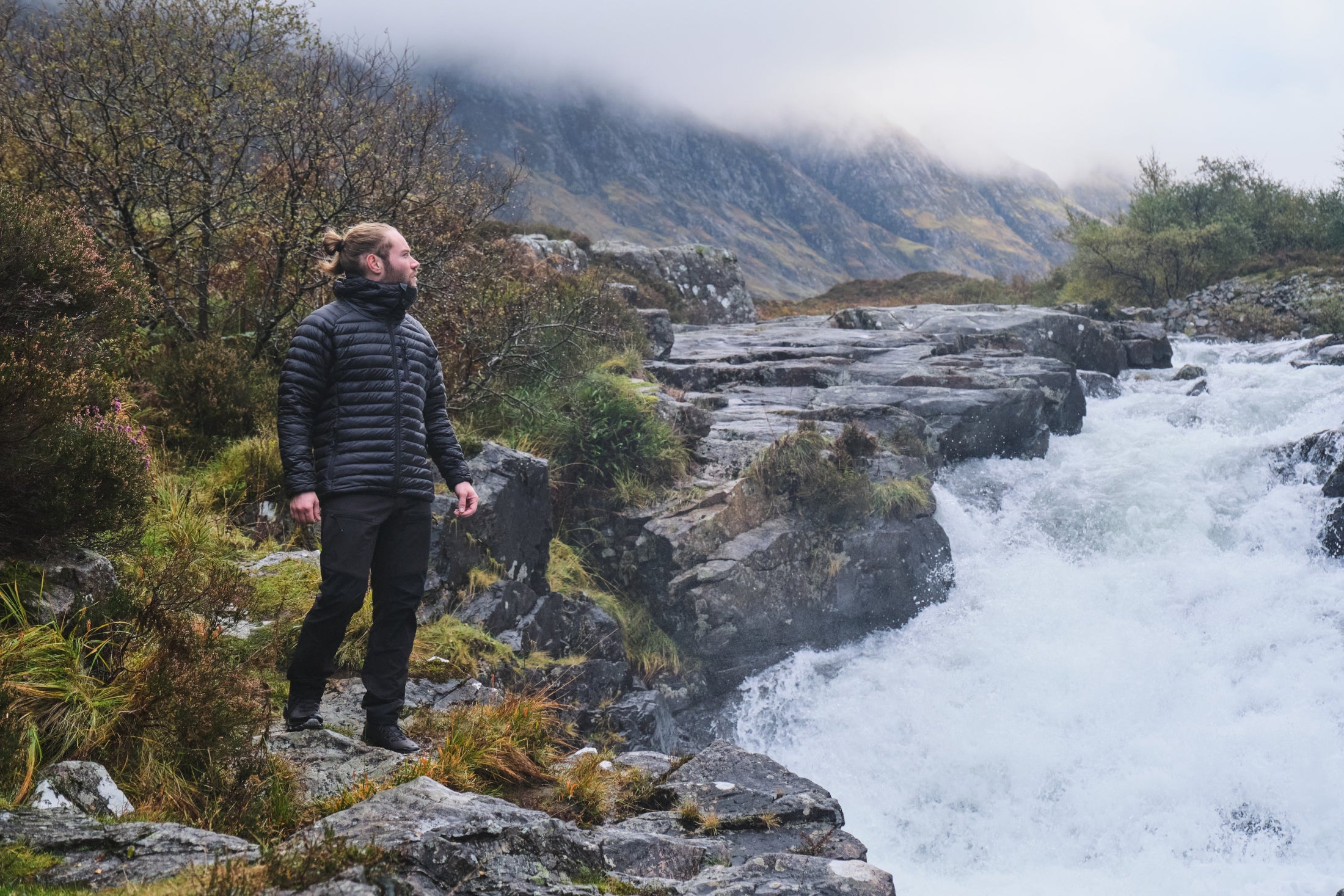 Stealth Aktiv Jacket in a foggy Highland valley next to a white rapid flowing river
