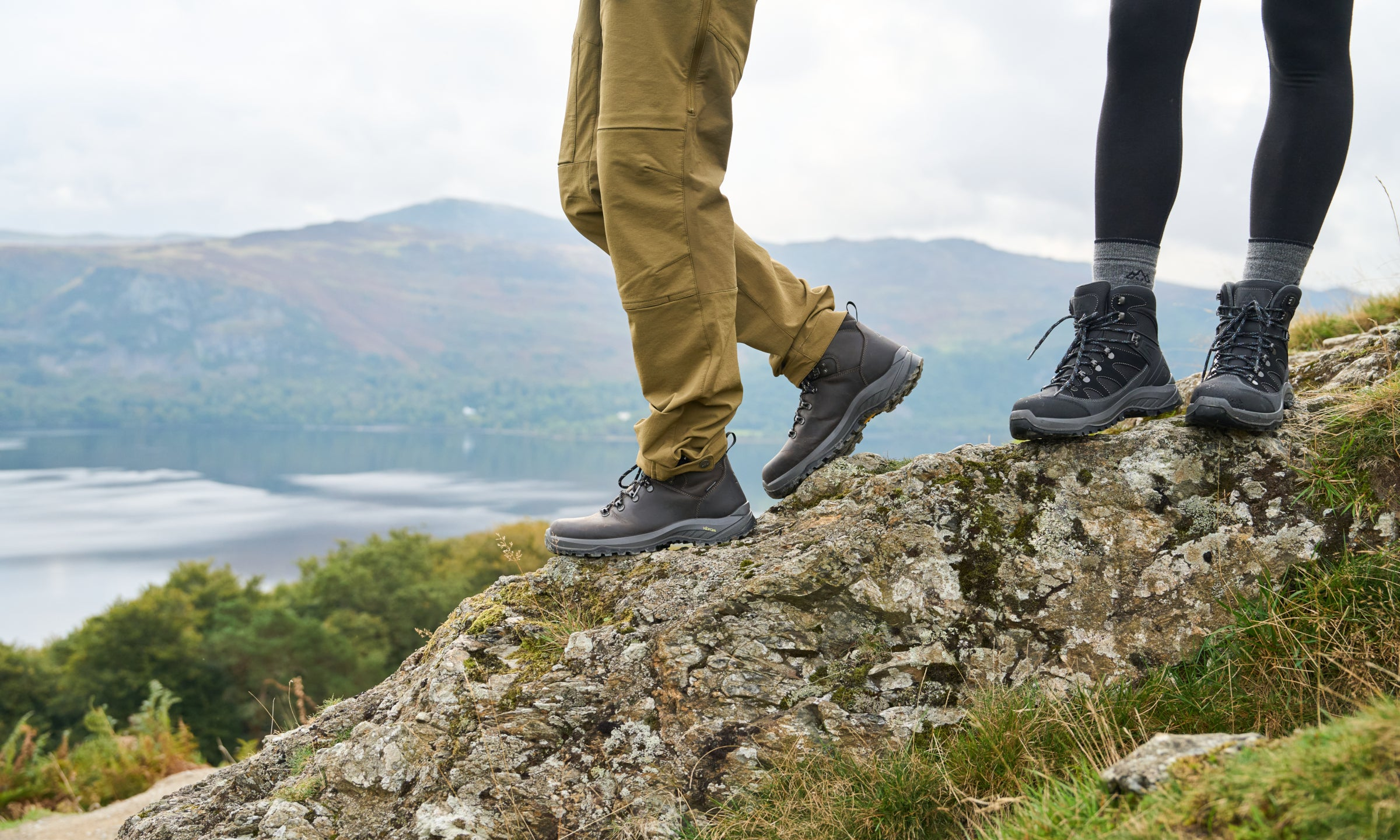 Two people wearing rugged hiking boots standing on a rocky outcrop