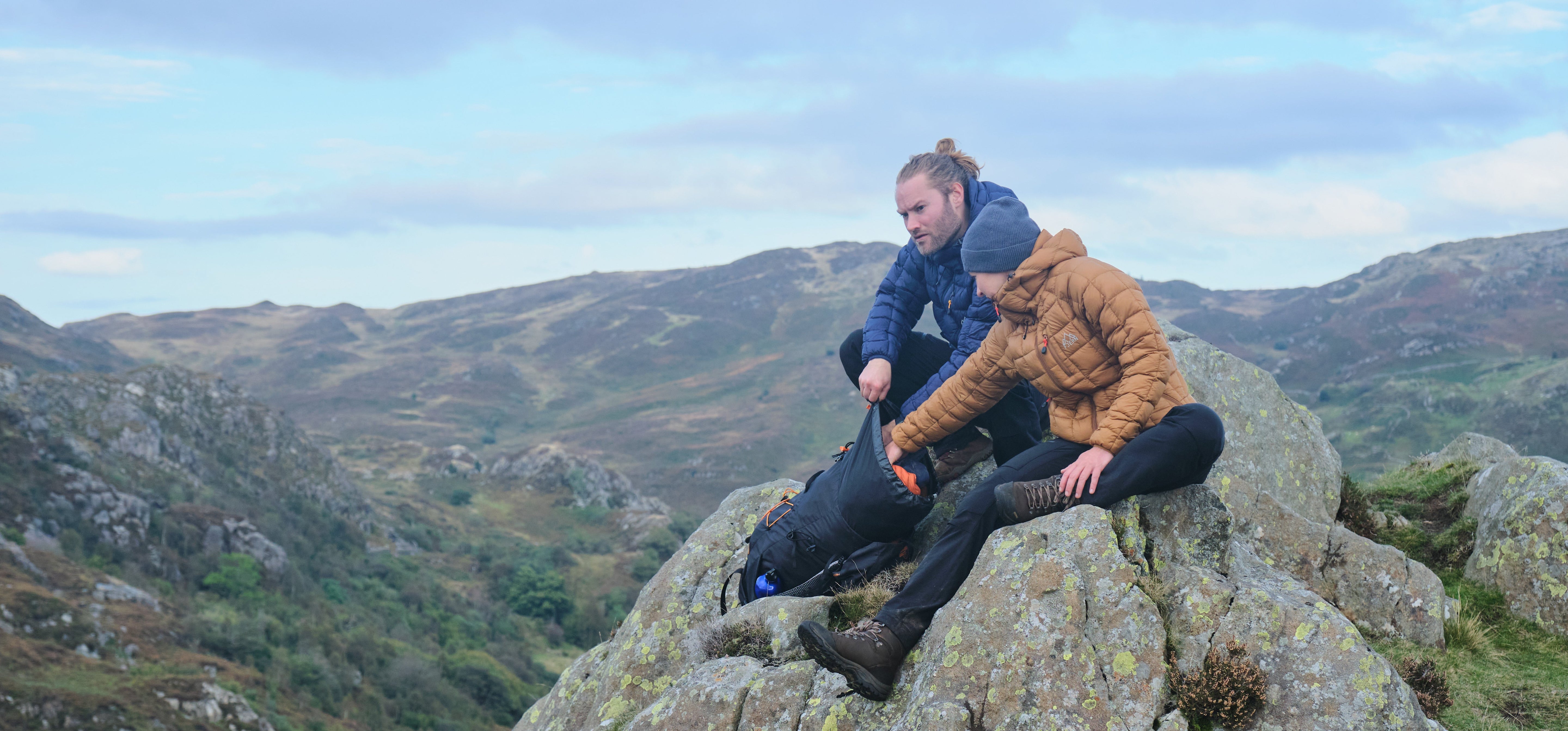 Fjern Eldur Insulated Jacket (Navy & Mustard) on a large boulder