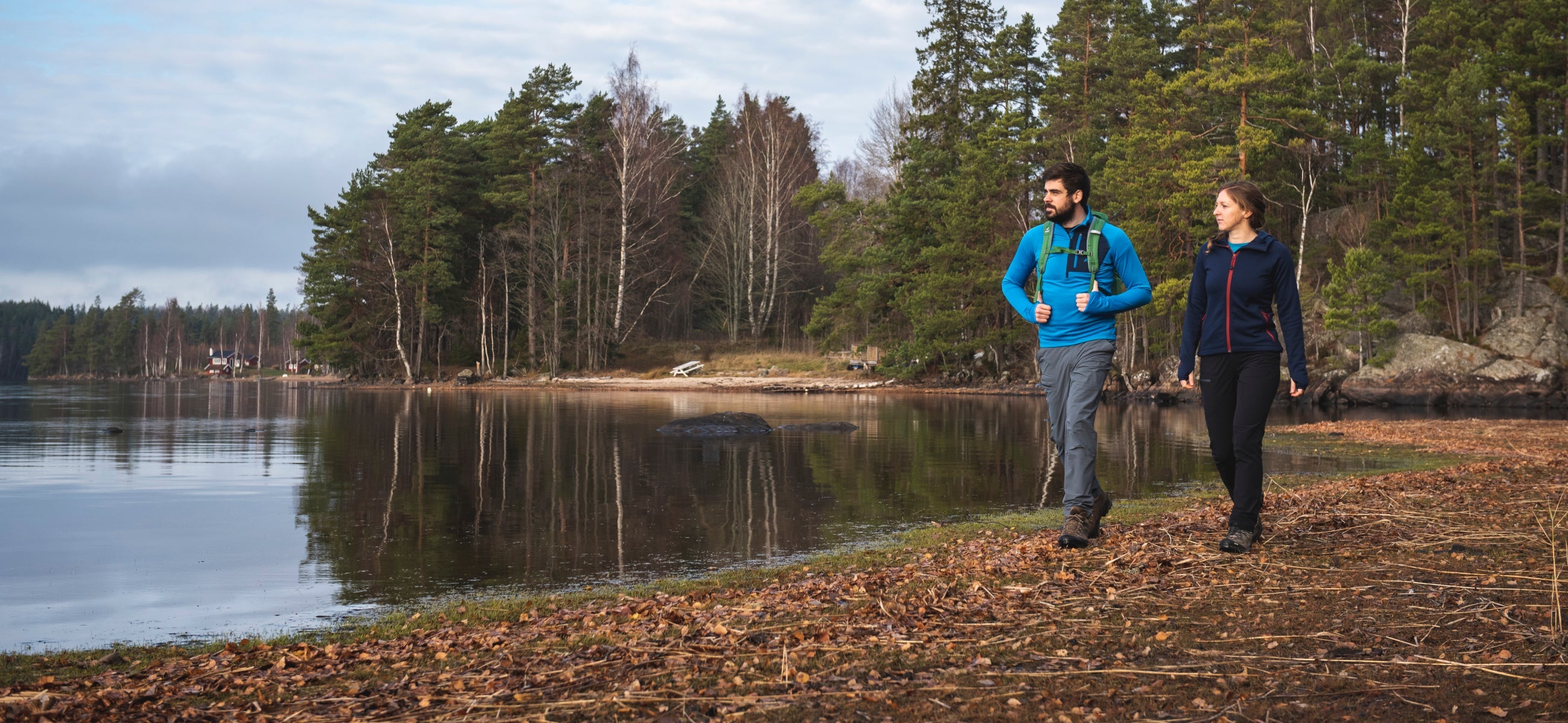 Fjern Nord Softshell Trousers walking next to a forest lake