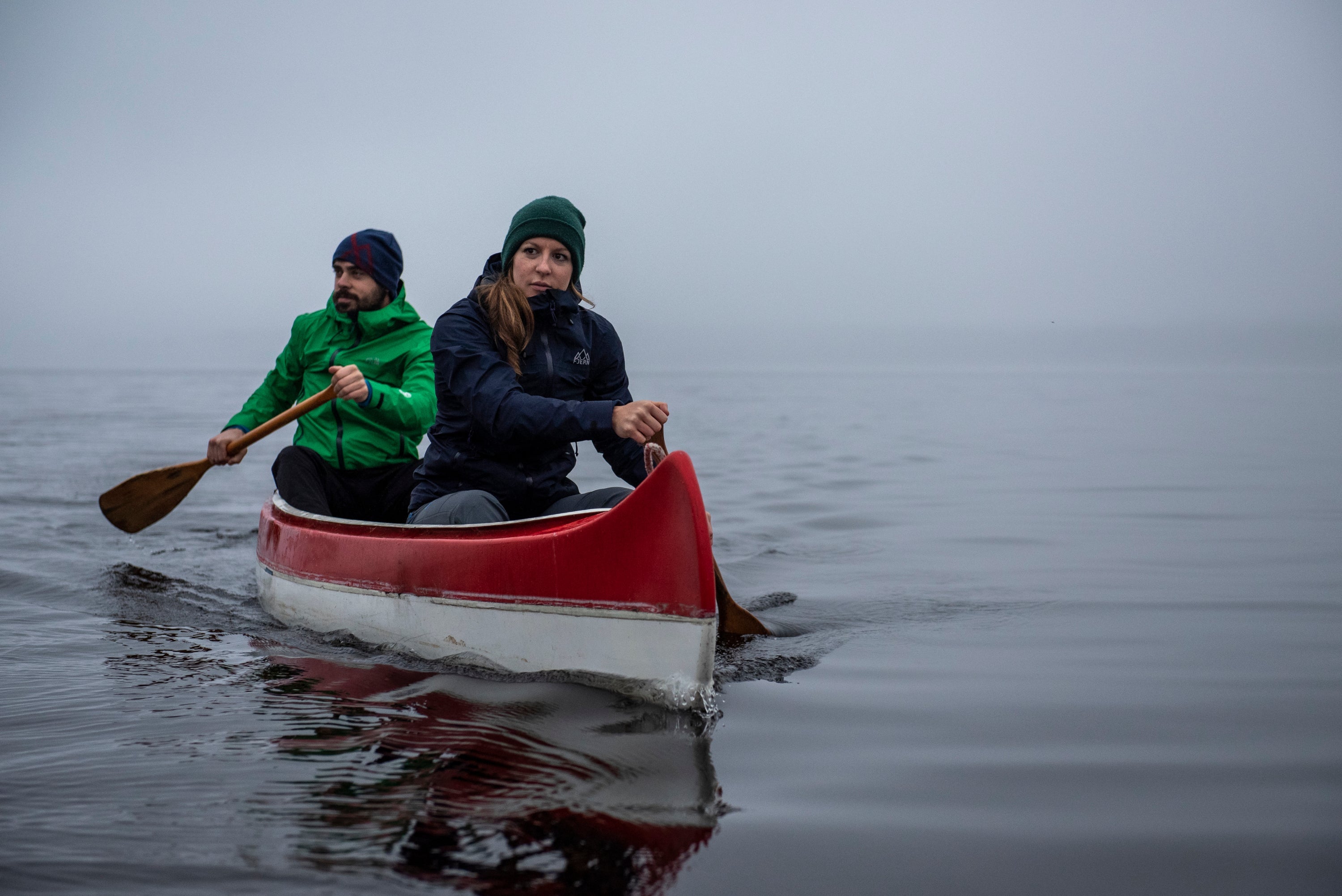 Fjern Skjold Packable Jacket on a canoe paddling across a foggy lake