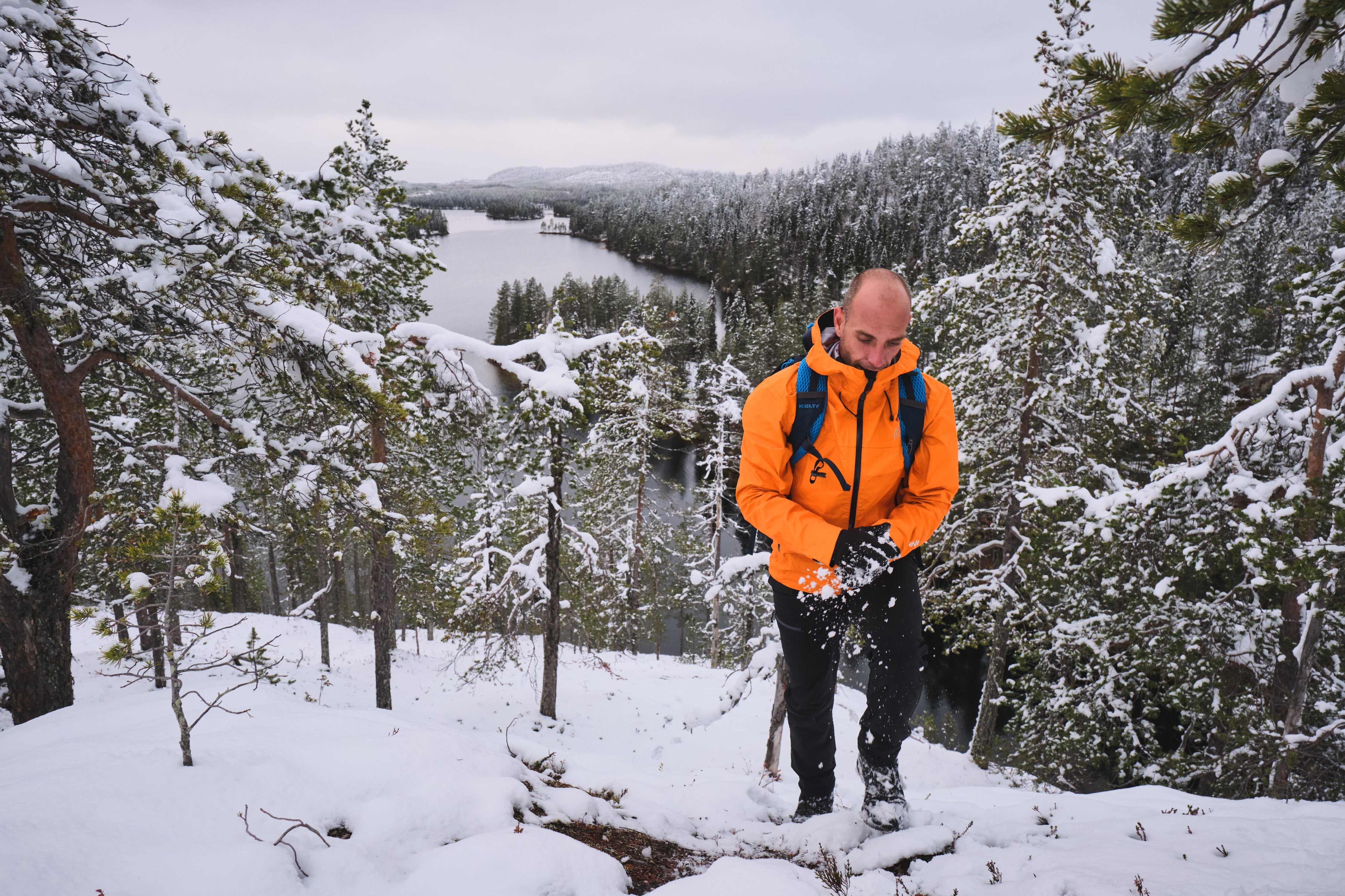 Fjern Aktiv Jacket hiking up a snowy hill in Finland