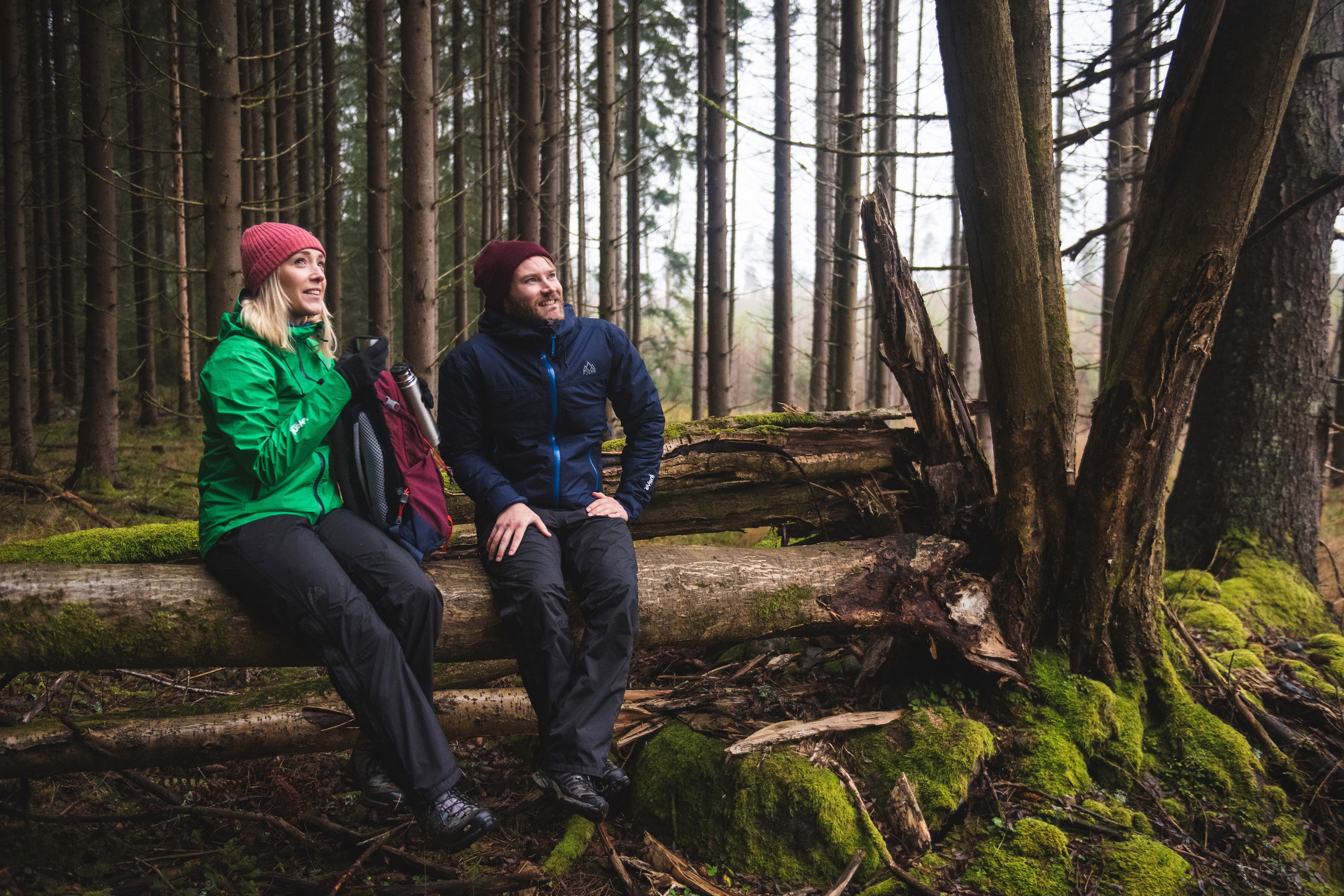 Fjern Vanntett Waterproof Trousers sat on a fallen tree in a mossy forest