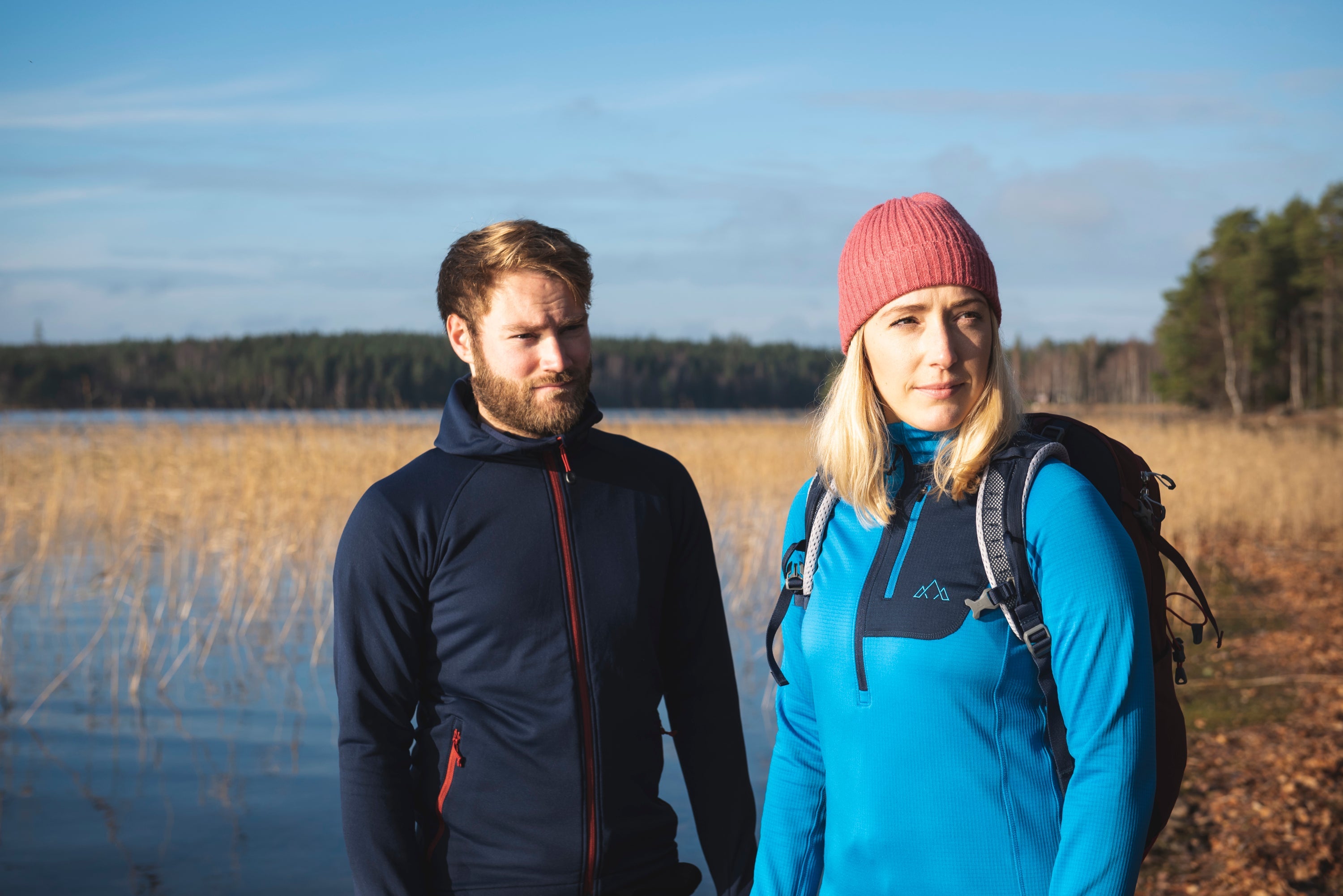 Fjern Skylon Hoodie and Bresprekk Fleece worn on the shore of a forest lake 