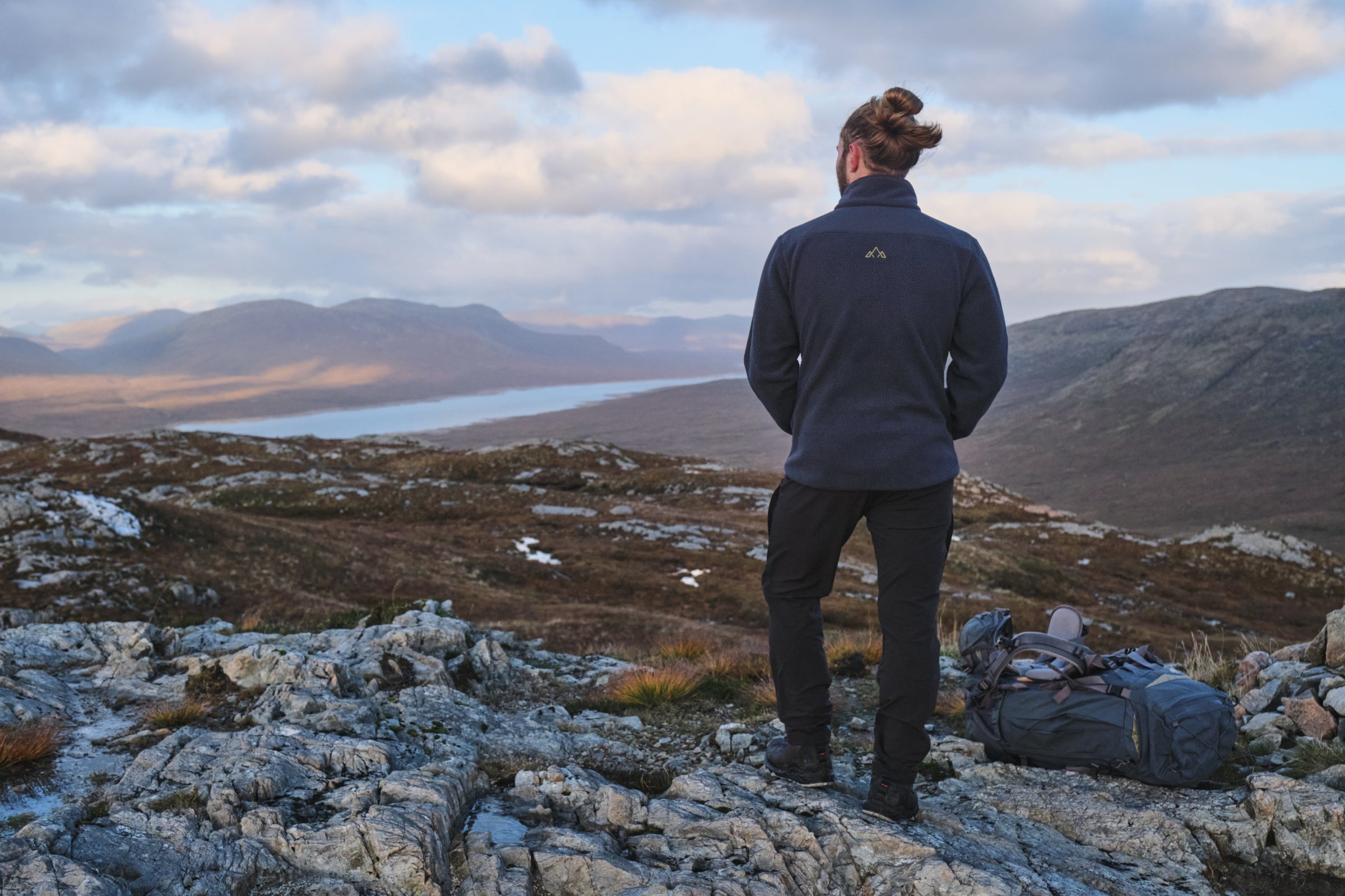 Hiker wearing Fjern fleece overlooking mountains and a lake
