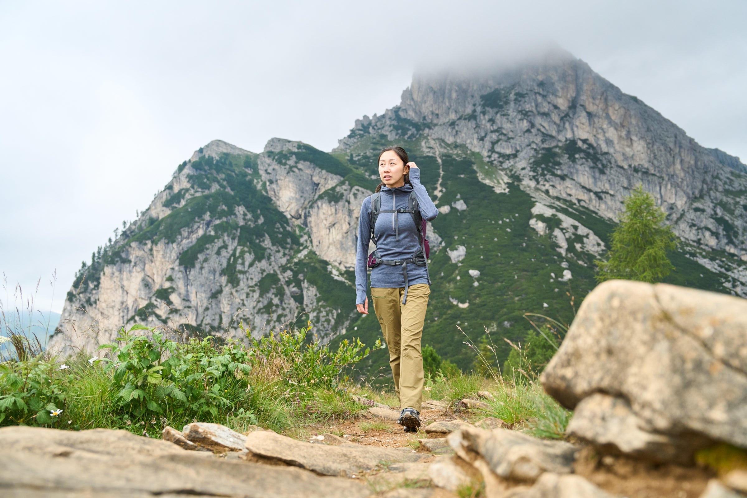 Woman hiking in mountains wearing Fjern baselayer and backpack