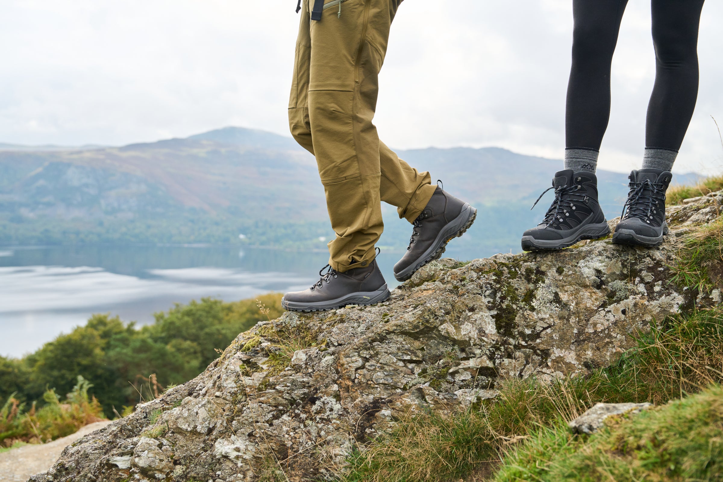 Two people wearing rugged hiking boots standing on a rocky outcrop