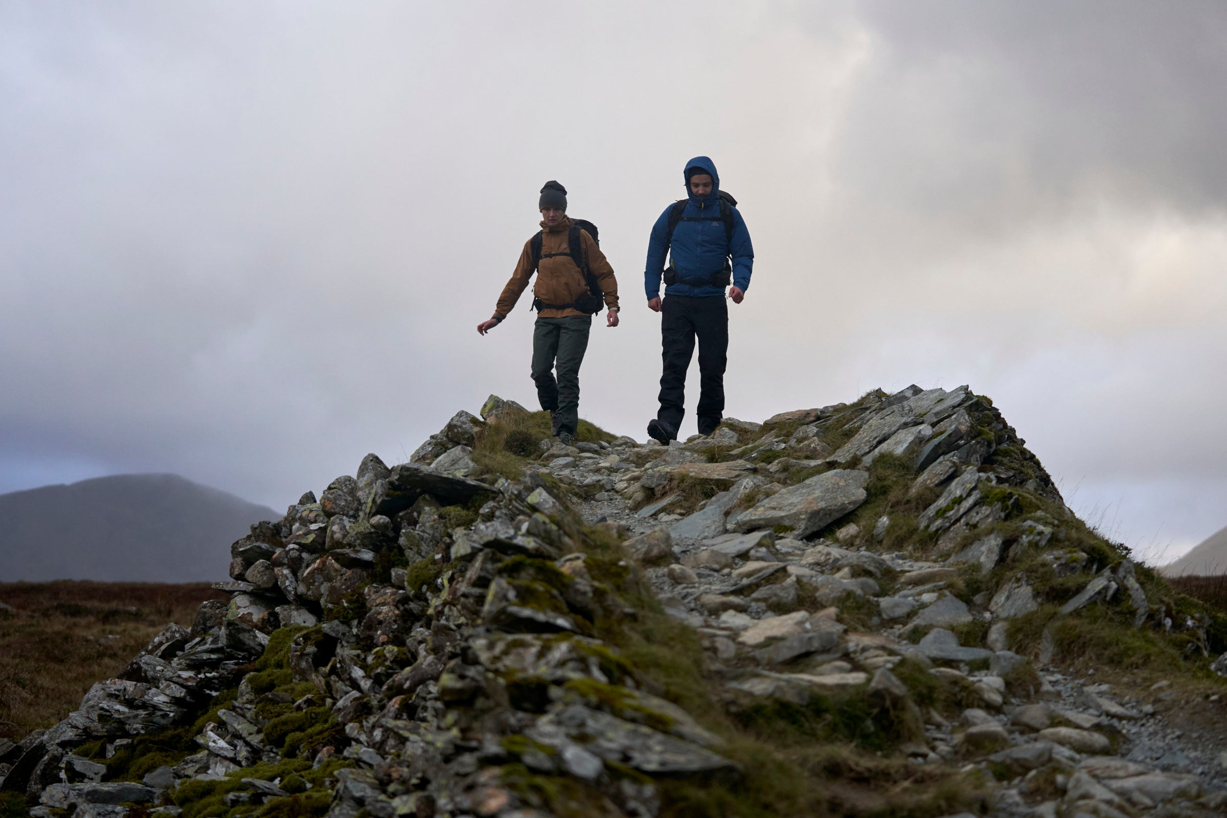 Two hikers walking along a rocky ridge