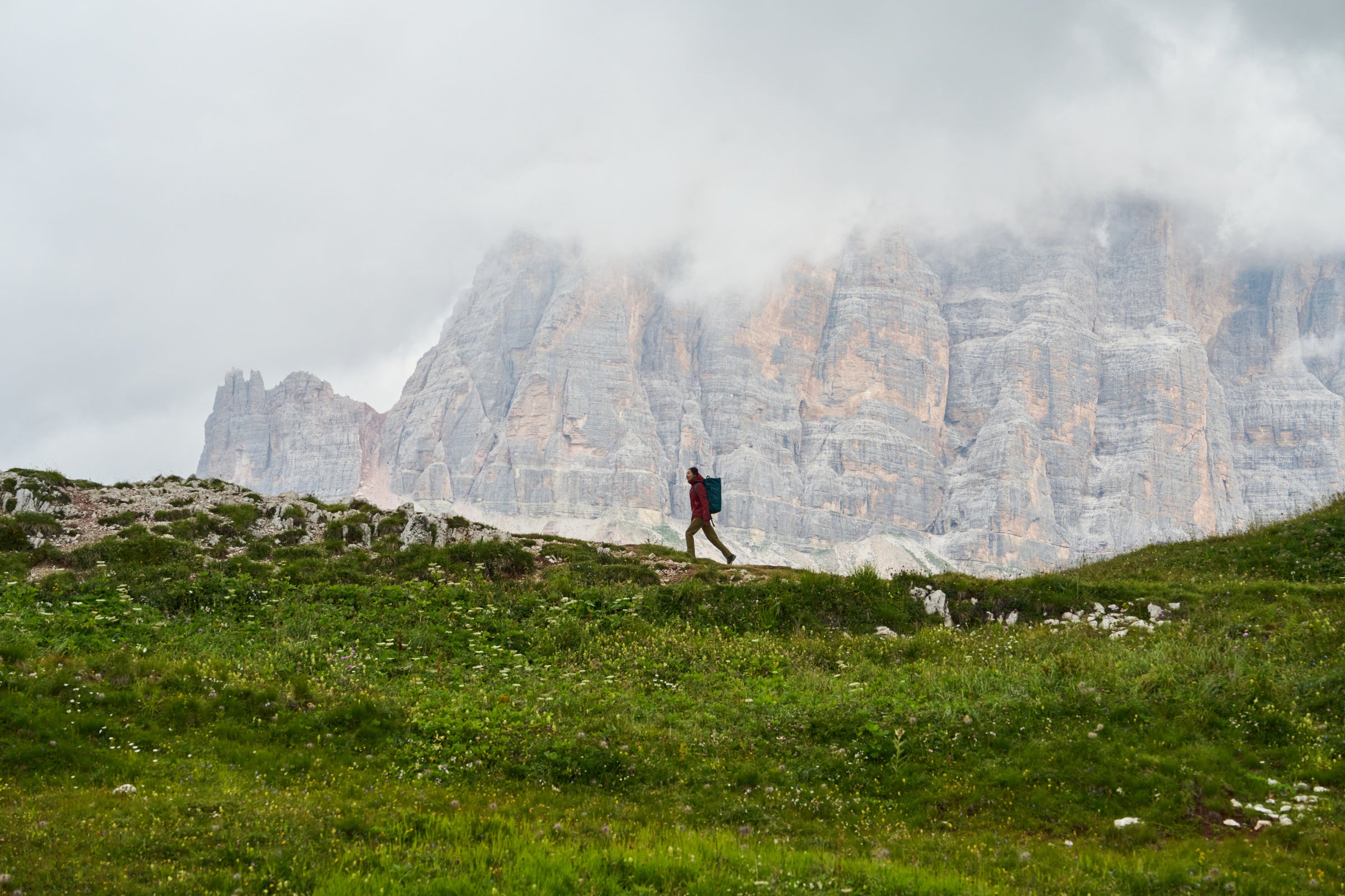 Fjern Field Notes - Striking photo of a hiker in front of a cloudy Dolomite cliff