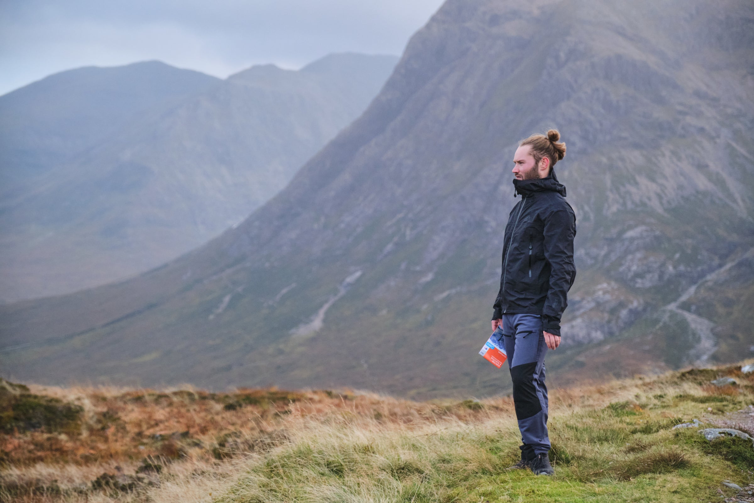 Person in waterproof jacket overlooking mountain valley