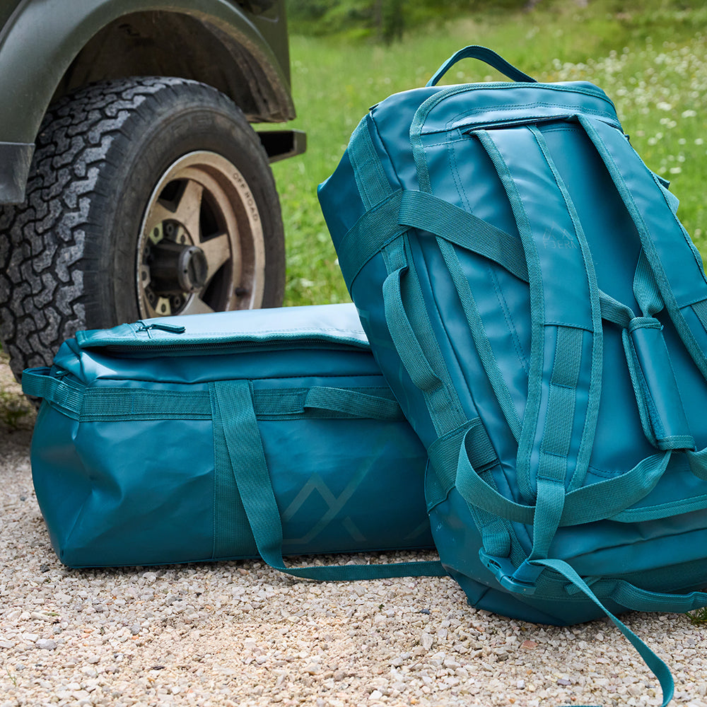 Fjern - Fördra 40L Duffle Bag (Petrol) | Made from durable 100% recycled polyester with a TPU-film laminate, the Fördra duffle bag offers 40L of storage, multiple pockets, and versatile carrying options