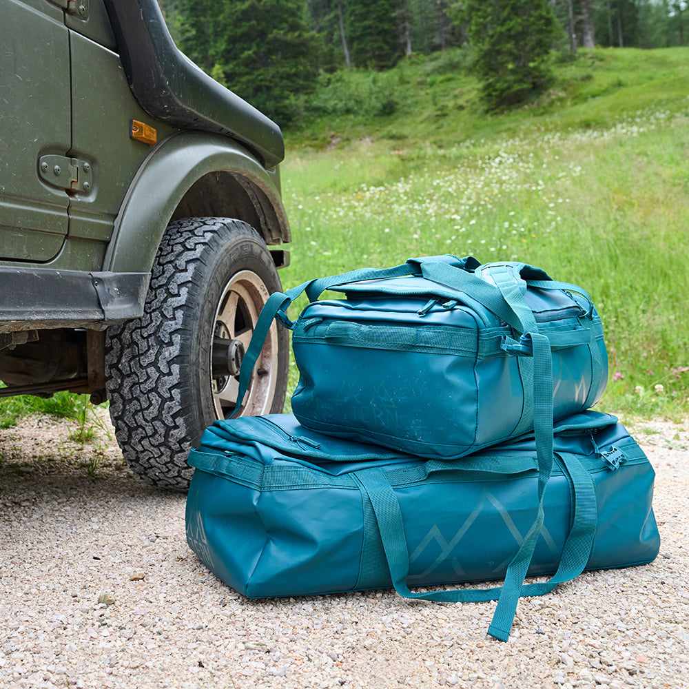 Fjern - Fördra 70L Duffle Bag (Petrol) | Made from durable 100% recycled polyester with a TPU-film laminate, the Fördra duffle bag offers 70L of storage, multiple pockets, and versatile carrying options