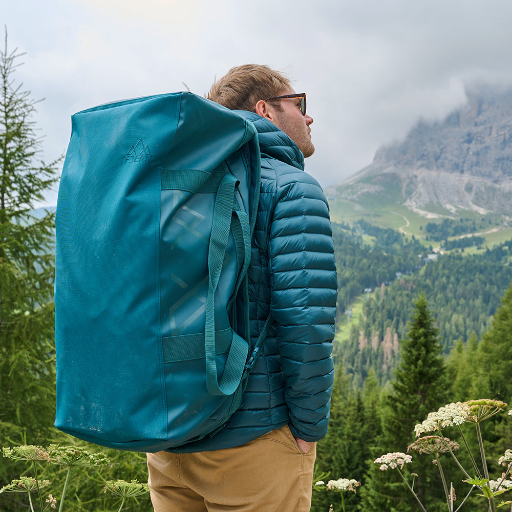 Fjern - Fördra 70L Duffle Bag (Petrol) | Made from durable 100% recycled polyester with a TPU-film laminate, the Fördra duffle bag offers 70L of storage, multiple pockets, and versatile carrying options