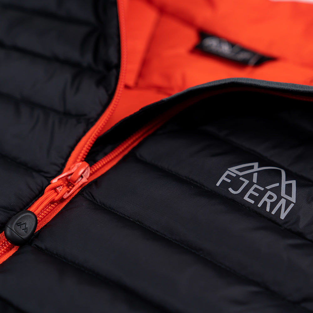 Fjern - Mens Aktiv Down Gilet (Black/Orange) | Gear up your alpine performance with the Aktiv Gilet, a versatile and lightweight insulated layer that offers core warmth without the bulk